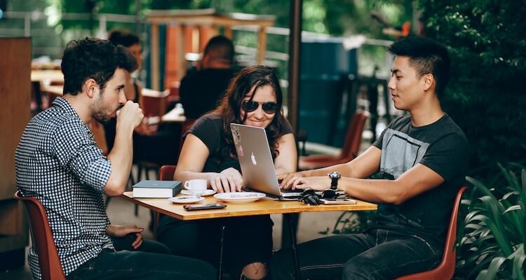 photo of three person sitting and talking