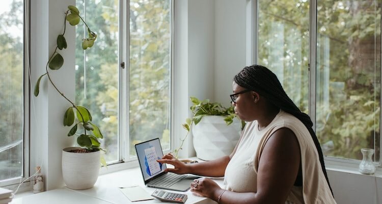 a woman sitting at a table with a laptop